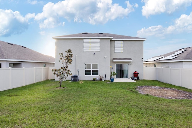 back of house featuring cooling unit, a patio, and a yard