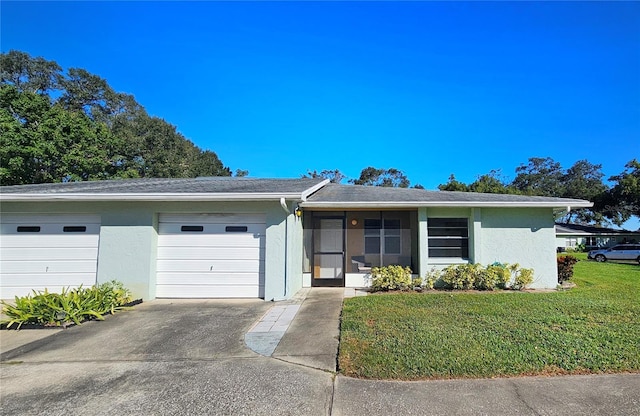 view of front facade with concrete driveway, a front lawn, an attached garage, and stucco siding