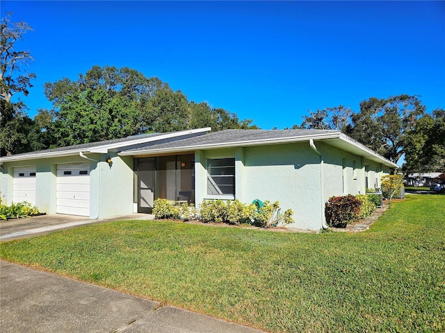 ranch-style home featuring a garage and a front lawn