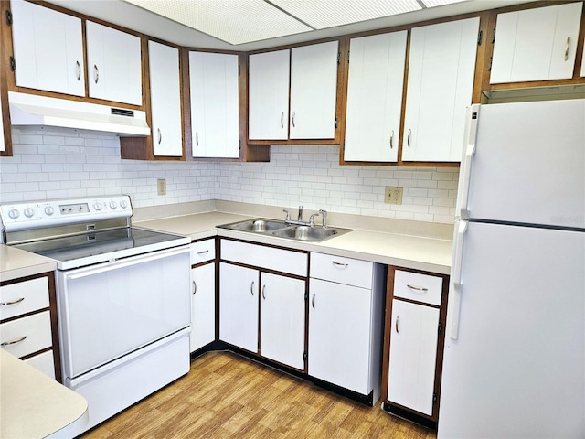 kitchen featuring white appliances, white cabinets, a sink, and under cabinet range hood