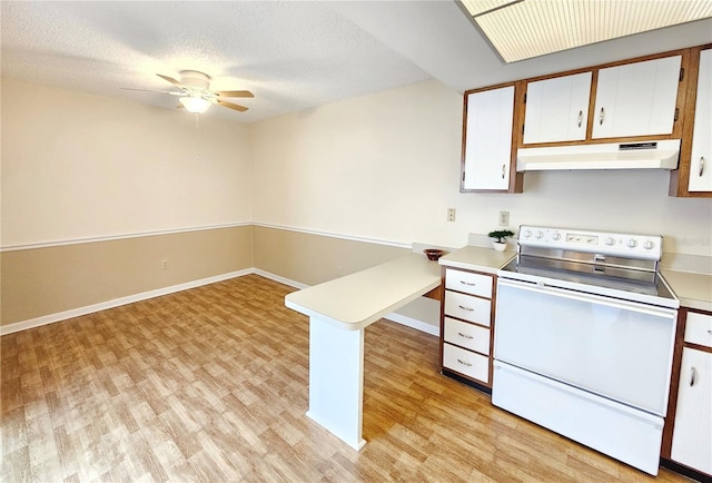 kitchen with under cabinet range hood, white cabinetry, light countertops, light wood finished floors, and white range with electric cooktop