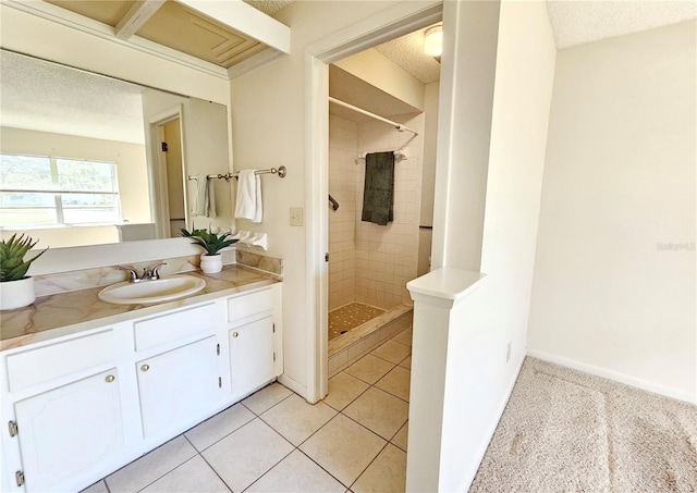 bathroom with a stall shower, a textured ceiling, vanity, baseboards, and tile patterned floors