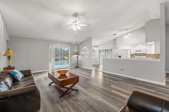 8404 Millwood Dr, Hudson, FL 34667 - living room featuring a ceiling fan, a textured ceiling, vaulted ceiling, dark wood finished floors, and baseboards