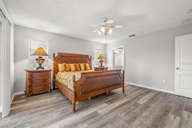 bedroom with a textured ceiling, hardwood / wood-style floors, and ceiling fan