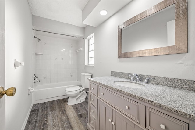 full bathroom featuring toilet, tiled shower / bath combo, vanity, and hardwood / wood-style floors