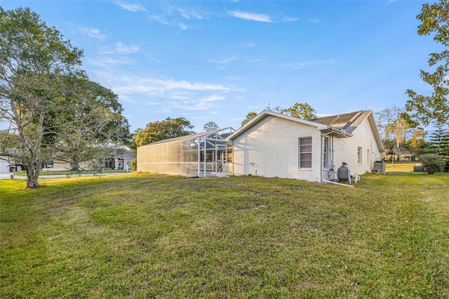 8404 Millwood Dr, Hudson, FL 34667 - view of side of home with a lawn, stucco siding, and glass enclosure