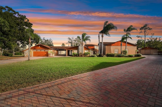 ranch-style home with a garage and a lawn