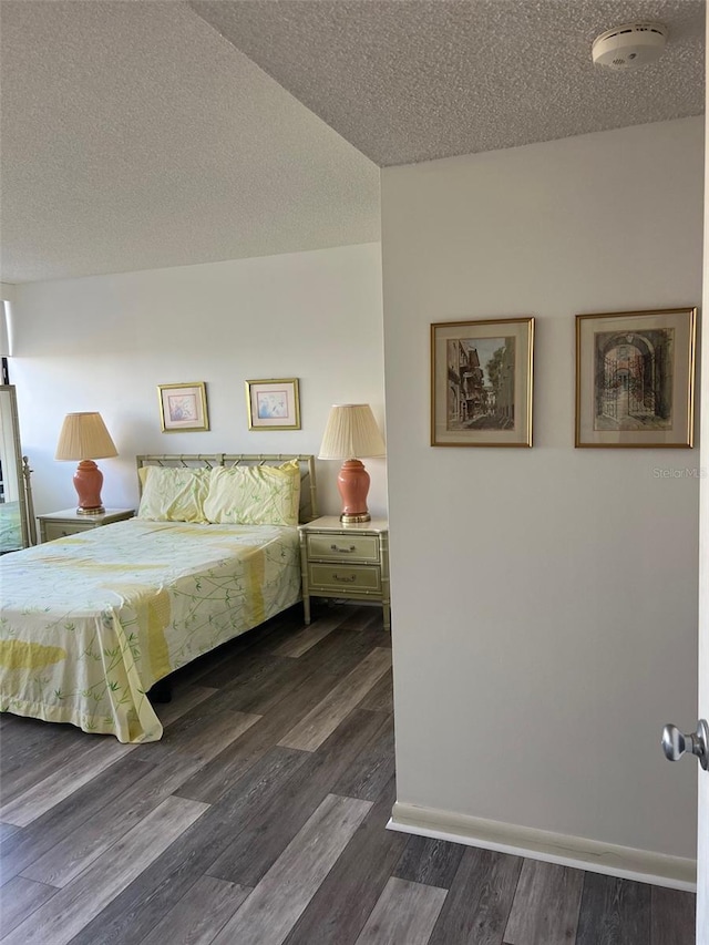 bedroom with dark hardwood / wood-style flooring and a textured ceiling