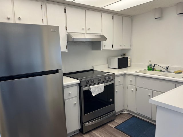 kitchen with white cabinets, appliances with stainless steel finishes, sink, and dark hardwood / wood-style floors