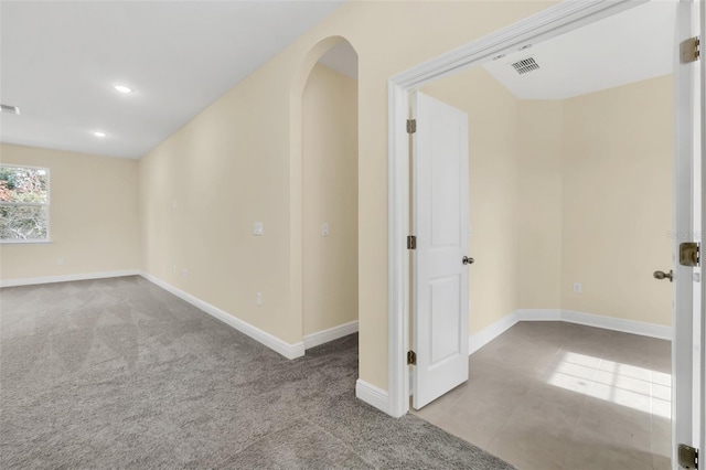 unfurnished room featuring light carpet