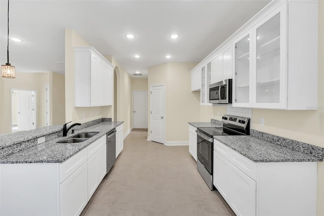 kitchen with pendant lighting, appliances with stainless steel finishes, sink, and white cabinets