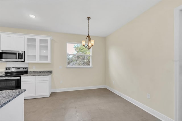 kitchen with tasteful backsplash, light stone counters, stainless steel appliances, an inviting chandelier, and white cabinets