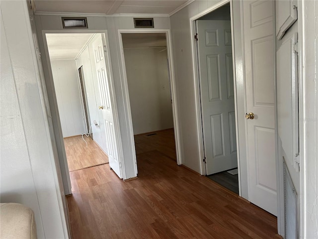 corridor with dark hardwood / wood-style flooring and ornamental molding