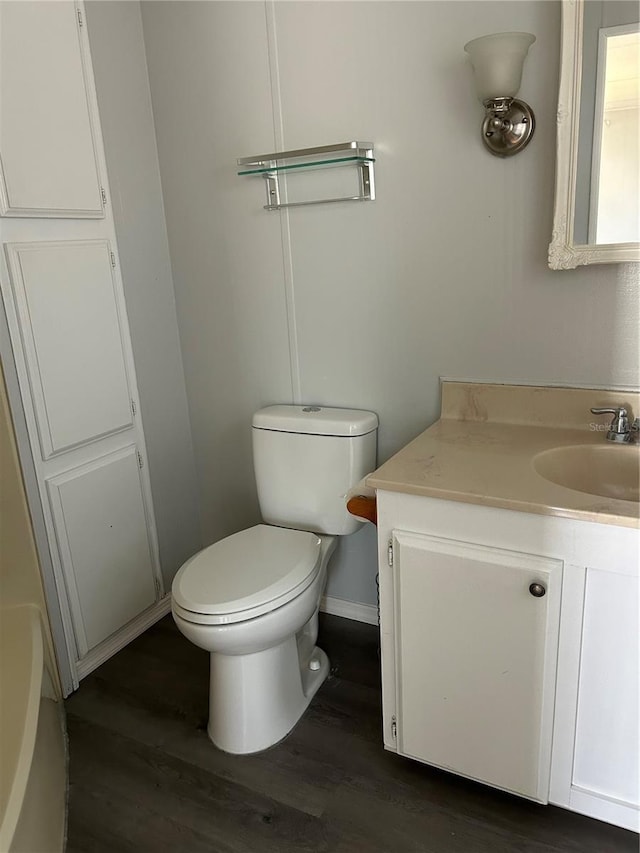 bathroom with hardwood / wood-style flooring, vanity, and toilet