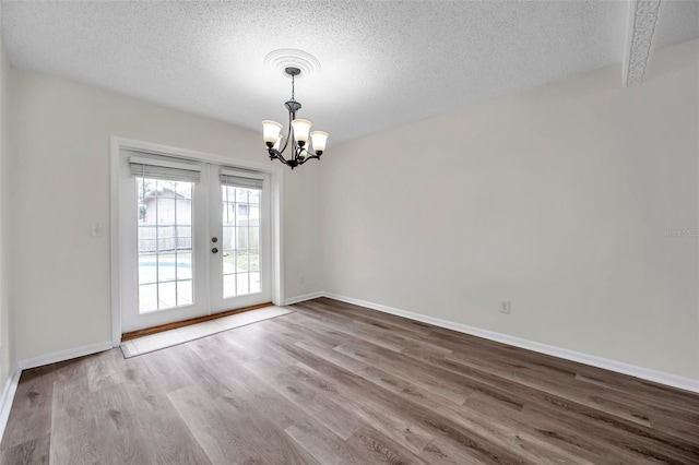 spare room featuring wood-type flooring, a textured ceiling, and french doors