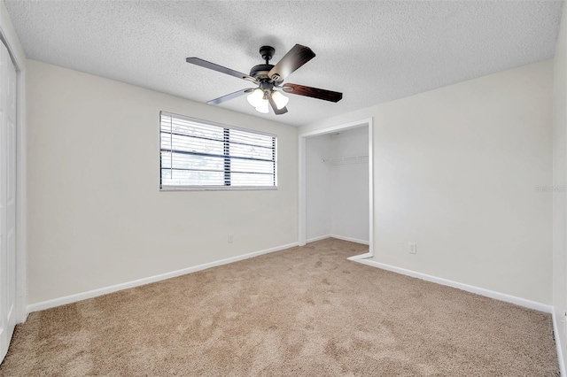 carpeted empty room with ceiling fan and a textured ceiling