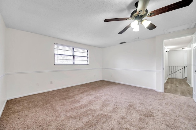 carpeted empty room with a textured ceiling and ceiling fan