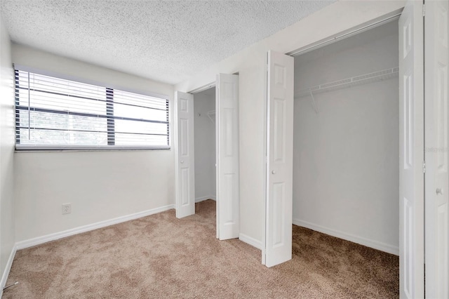 unfurnished bedroom with a closet, light colored carpet, and a textured ceiling