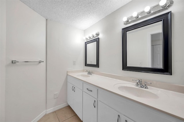 bathroom with tile patterned floors, vanity, and a textured ceiling