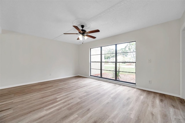 empty room featuring ceiling fan, light hardwood / wood-style flooring, and a textured ceiling