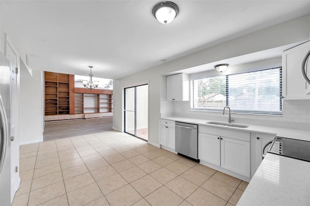 kitchen with pendant lighting, dishwasher, sink, tasteful backsplash, and white cabinetry