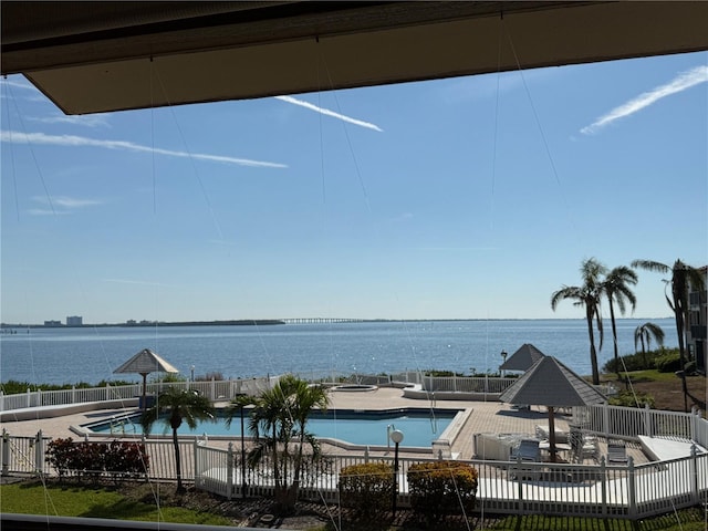 view of swimming pool featuring a water view and a patio