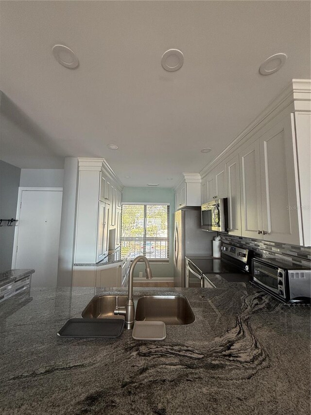 6268 Palma Del Mar Blvd S Unit 215, Saint Petersburg, FL 33715 - kitchen with appliances with stainless steel finishes, a sink, white cabinetry, and dark stone countertops