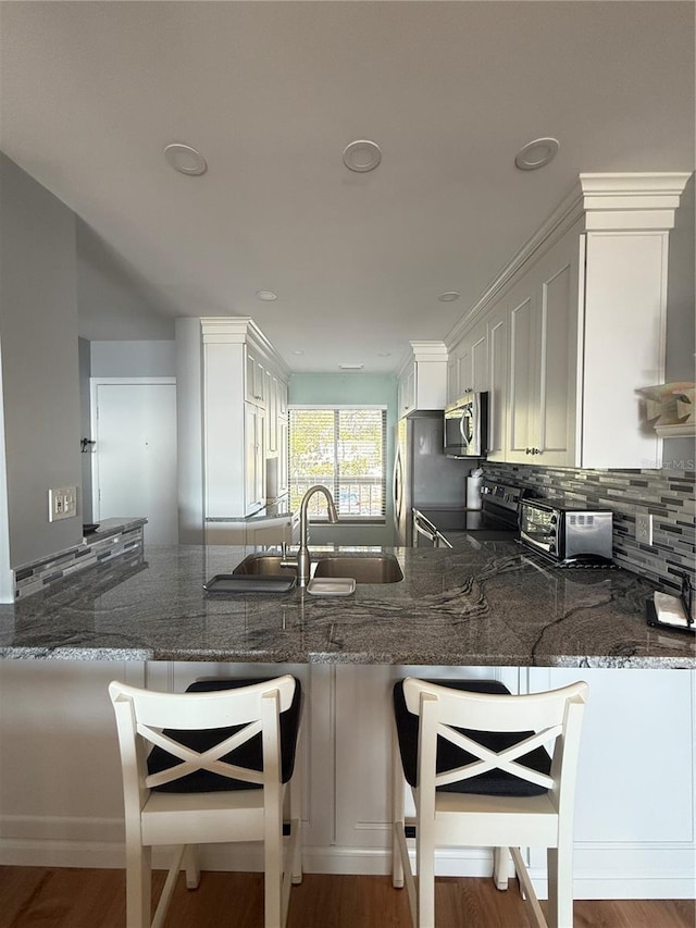 6268 Palma Del Mar Blvd S Unit 215, Saint Petersburg, FL 33715 - kitchen featuring stainless steel appliances, a peninsula, dark stone countertops, and tasteful backsplash