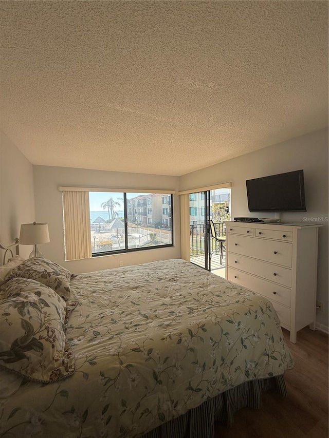6268 Palma Del Mar Blvd S Unit 215, Saint Petersburg, FL 33715 - bedroom featuring access to outside, a textured ceiling, and light wood-type flooring