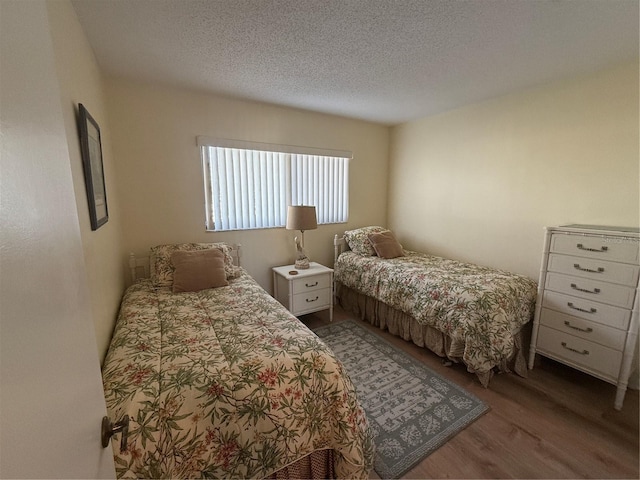 bedroom featuring hardwood / wood-style floors and a textured ceiling