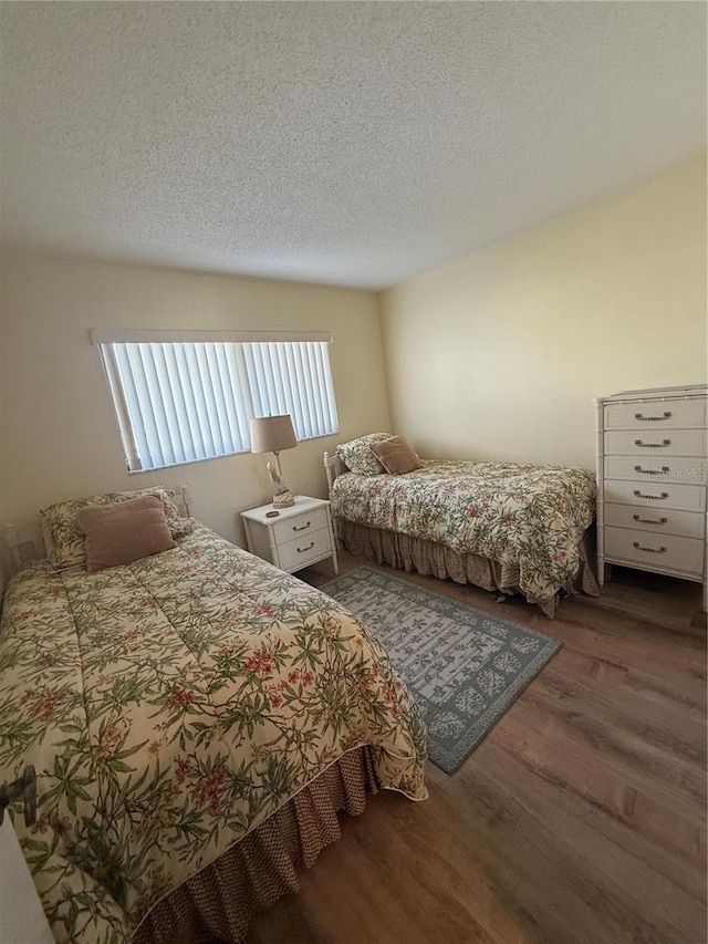 bedroom with dark hardwood / wood-style flooring and a textured ceiling