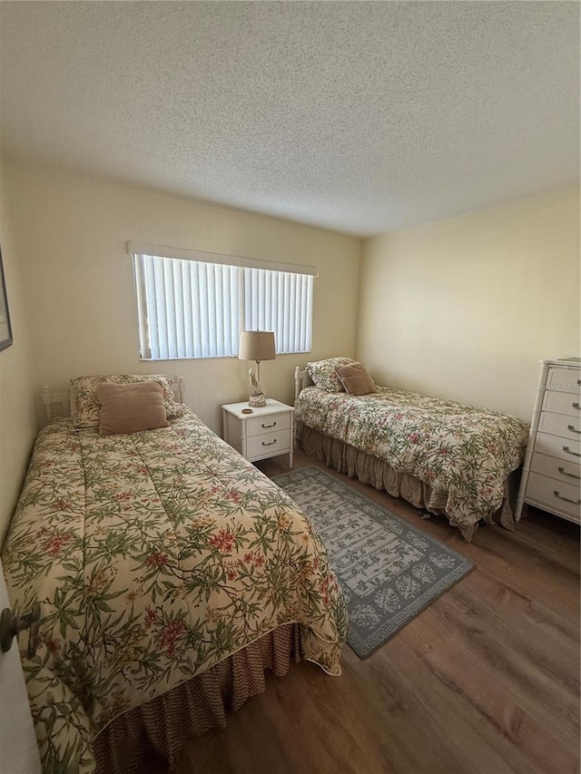 bedroom featuring hardwood / wood-style floors and a textured ceiling