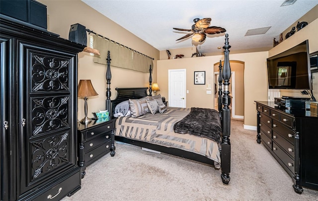 bedroom featuring a textured ceiling, light colored carpet, and ceiling fan