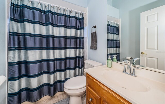 bathroom featuring tile patterned flooring, vanity, curtained shower, and toilet