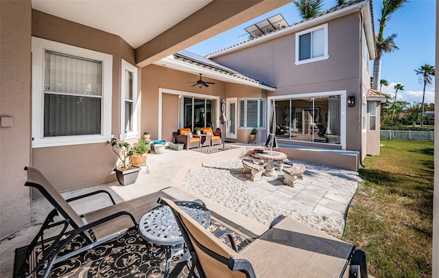 back of property with ceiling fan and a patio