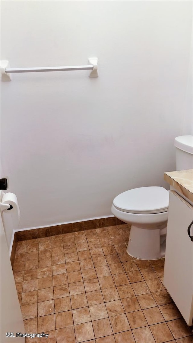 bathroom featuring vanity, tile patterned floors, and toilet