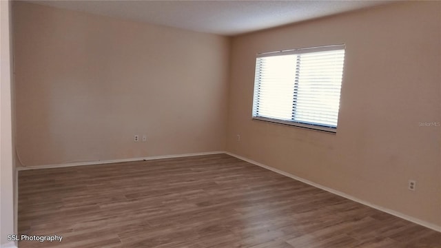 unfurnished room with hardwood / wood-style flooring