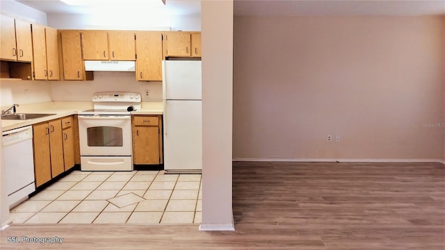 kitchen featuring white appliances, sink, and light tile patterned floors