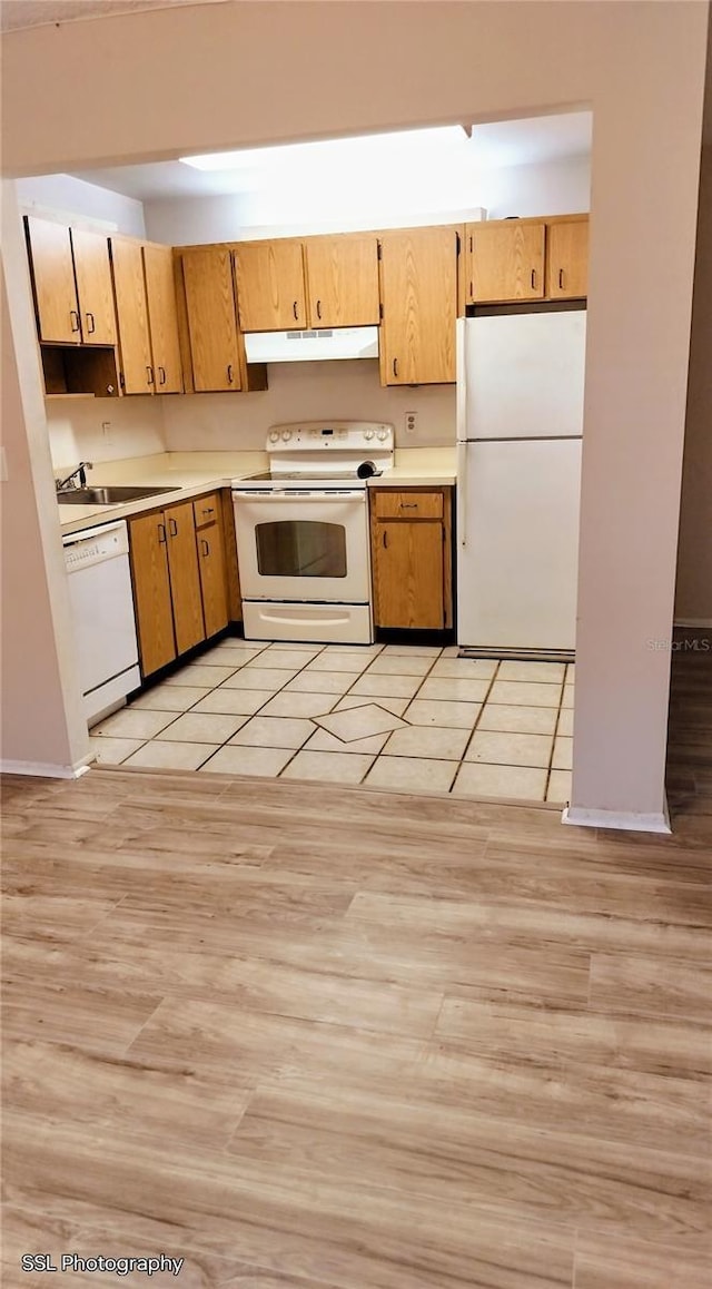 kitchen with sink, white appliances, and light tile patterned flooring