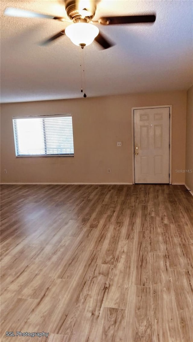 unfurnished room featuring ceiling fan, hardwood / wood-style floors, and a textured ceiling