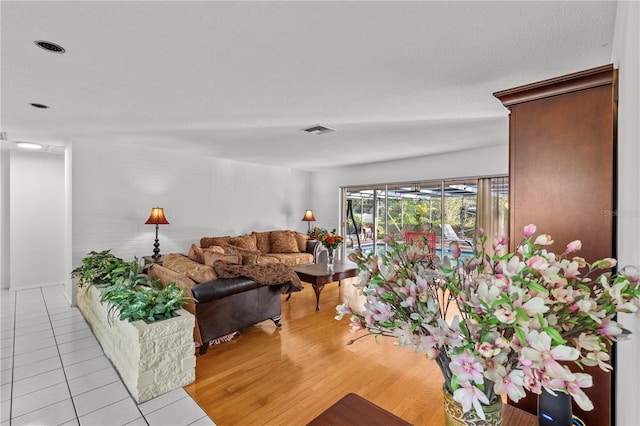 living room with a textured ceiling and light hardwood / wood-style floors