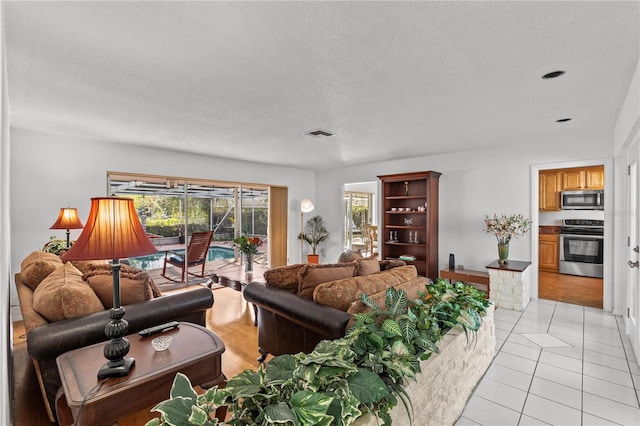 living room featuring a textured ceiling and light tile patterned floors