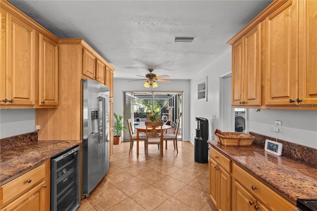2516 Roberta St, Largo, FL 33771 - kitchen featuring stainless steel fridge, beverage cooler, ceiling fan, light tile patterned floors, and dark stone counters