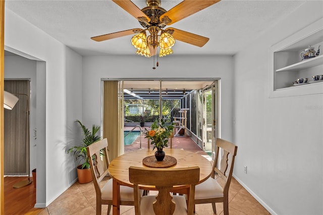 tiled dining area featuring built in shelves, a textured ceiling, and ceiling fan