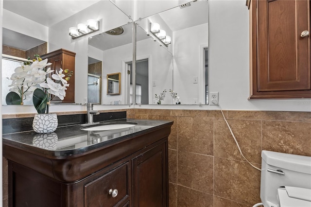 2516 Roberta St, Largo, FL 33771 - bathroom with toilet, tile walls, vanity, and wainscoting