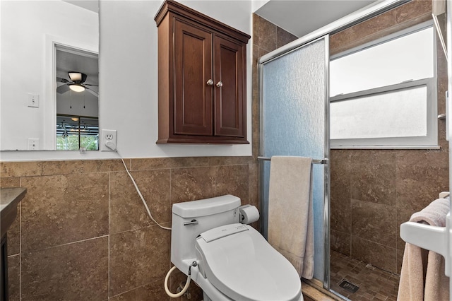 bathroom featuring toilet, an enclosed shower, tile walls, and ceiling fan