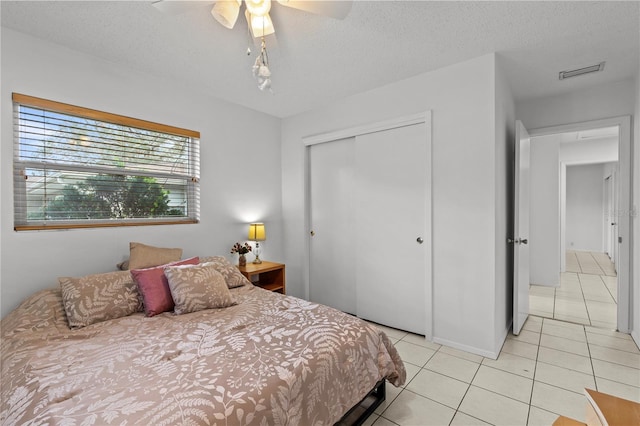 2516 Roberta St, Largo, FL 33771 - bedroom with light tile patterned floors, a closet, a ceiling fan, and a textured ceiling