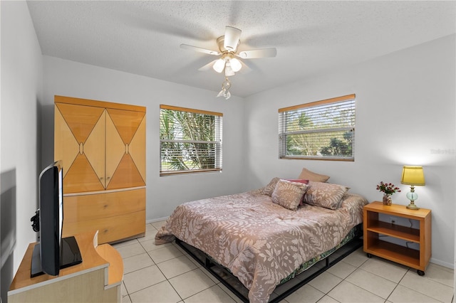 bedroom with a textured ceiling, ceiling fan, and light tile patterned flooring