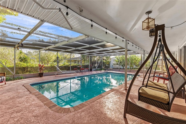 view of pool featuring glass enclosure and a patio area