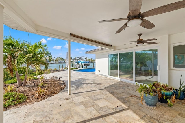 view of patio with ceiling fan and a water view